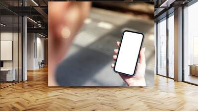 Woman uses smartphone with blank frameless screen on the train  station - template for mobile applications Wall mural