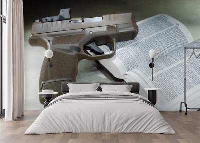 Loaded pistol on an open bible Wall mural