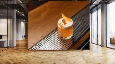 A close-up of the ready-made delicious alcoholic cocktail peach sour stands on the bar and waits for the guest Wall mural