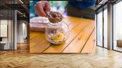 Close-up of a waiter in a cafe taking a scoop of ice cream with an ice cream spoon and putting it into a glass  Wall mural