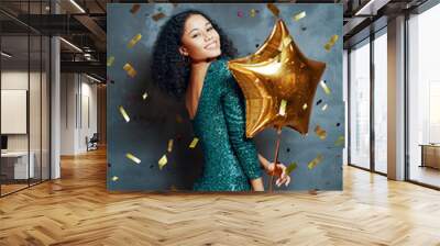 Beautiful young african woman having fun and holding golden balloon Wall mural