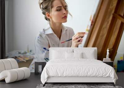 Closeup of beautiful woman painting on canvas in studio Wall mural