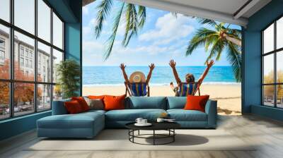 Happy couple with arms up relax on the beach enjoy beautiful sea on the tropical island Wall mural