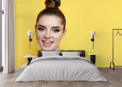 Headshot portrait of young happy woman smiling and looks at camera with copy space Wall mural