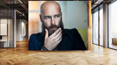 Portrait of bearded thoughtful man strokes beard Wall mural