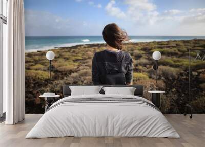 Young girl with backpack enjoying coast of island Lanzarote Wall mural