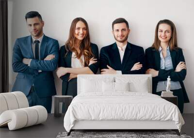 Young smiling business people with arms crossed lean to wall in office Wall mural