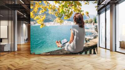 Young woman relaxing on beautiful Garda lake Wall mural