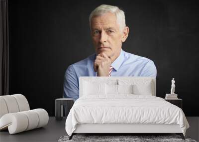 Elderly man portrait. An executive senior man wearing shirt and tie while sitting at isolated black background.  Wall mural