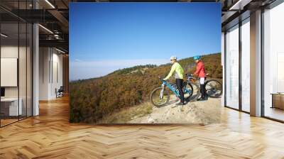 Two female cyclist enjoying the beautiful scenery while out mountain biking. Wall mural