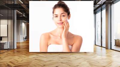 Young woman applying cream onto her face Wall mural