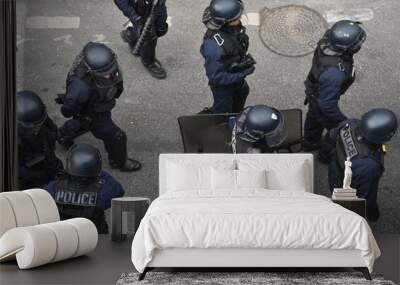 Helmeted police officers photographed from behind during a protest Wall mural