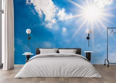 Beautiful, blue summer sky with fluffy clouds and bright sun as a background Wall mural