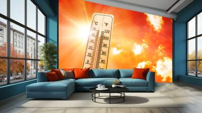 Orange sky with bright sun and thermometer symbolizing climate change and global warming Wall mural