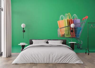 A shopping cart filled with colorful shopping bags against a green background. Wall mural