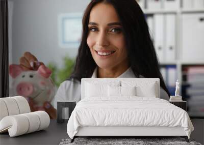 Close-up of businesslady putting money for dream in thrift-box. Smiling woman looking at camera with calmness and gladness. Piggy bank and economy concept Wall mural