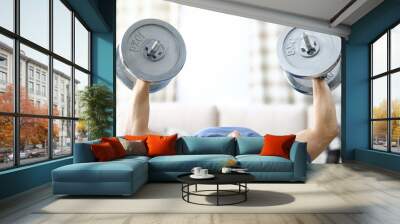 Close-up of strong and fit person lifting heavy dumbbells at home. Sport and active lifestyle. Adult laying on back and training for health and muscle body. Quarantine period concept Wall mural