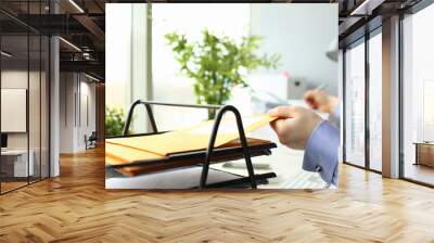 Cropped photo of male employee putting envelope on a shelf at his workplace Wall mural