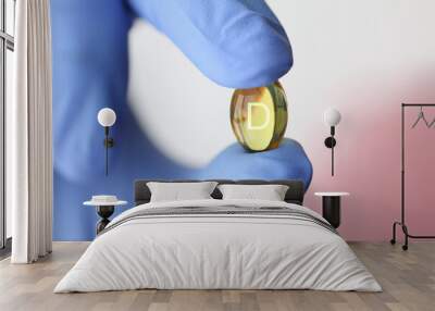 Doctor in rubber gloves holding vitamin D pill closeup. Treatment with biological food additives concept. Wall mural