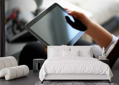 female hand holds tablet in home setting while Wall mural