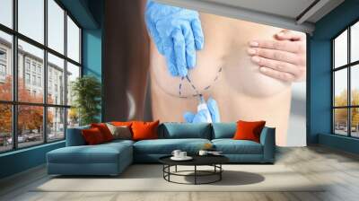 Hands draw with a marker on the female breast, close-up Wall mural