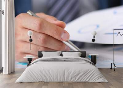 Male hands hold documents with financial statistics at office workspace closeup. White collar check money papers, stock exchange market, internal Revenue Service inspector, earning list concept Wall mural