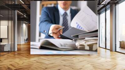 Male hands hold documents with financial statistics at office workspace closeup. White collar check money papers, stock exchange market, internal Revenue Service inspector, earning list concept Wall mural