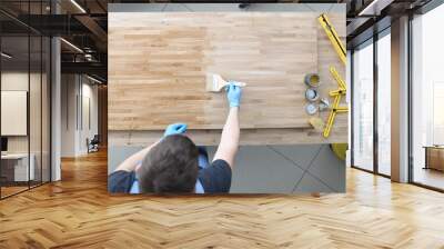 Master apply wood preservative with brush at workplace. Construction tool and equipment are on desktop. Furniture manufacturing and apartment renovation concept. Wall mural