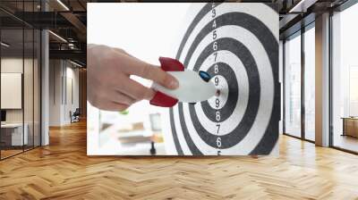 Rocket in hands of businessman hitting darts target closeup Wall mural