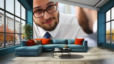 Smiling male in classic tie and glasses is talking with colleague who is holding financial chart Wall mural