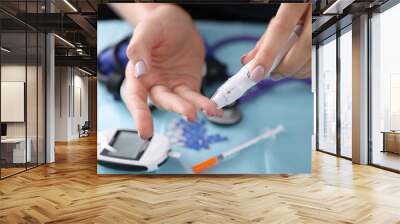 Woman drawing blood with lancet at home closeup. Blood glucose control in diabetes mellitus concept Wall mural