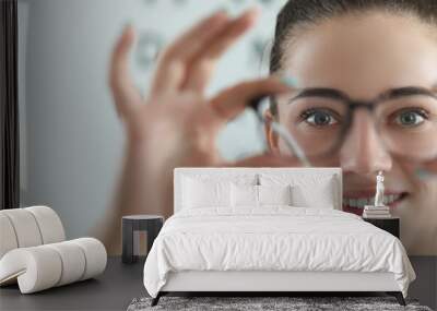 Woman eye doctor with eye test chart on background Wall mural