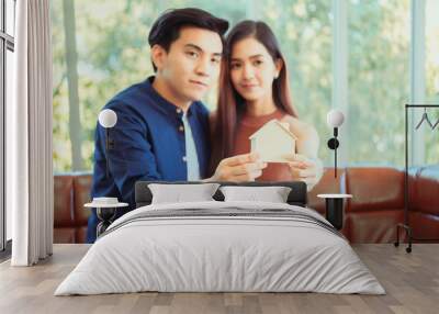 Asian teenage couple planning to buy and build his future new house with happy face in a modern apartment. Concept for real estate and saving money for family and home. Wall mural