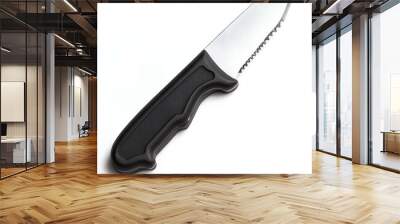 Close-up of a serrated knife with a black handle. Wall mural