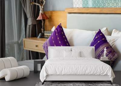 Purple pillow on white bed. Wall mural