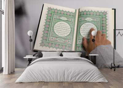 Reading the open Quran pages with fingers, recitation of the Islamic holy book Al-Quran Wall mural