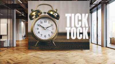 tick tock day concept - golden bell clock on a wooden table background with 