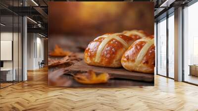 freshly baked cross buns on wooden table with autumn leaves Wall mural