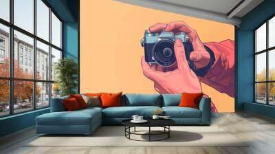 Person holding vintage camera with orange background. Wall mural