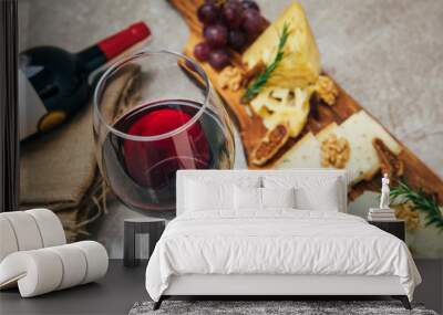 Glass of Wine and cheese. Assortment or various type of cheese, wine glass and bottle on the table in restaurant. Red, rose and yellow wine or champagne on the table. Winery concept image Wall mural