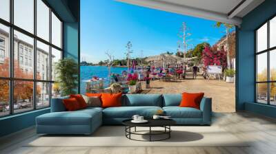 view of restaurant or cafe and bougainvillea flowers on beach in gumusluk, bodrum city of turkey. ae Wall mural