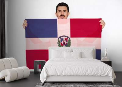 Young man holding Dominican Republic flag, two hands and white background, celebration or  Wall mural