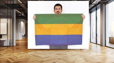 Young man holding Gabon flag, two hands and white background, celebration or campaigning concept Wall mural