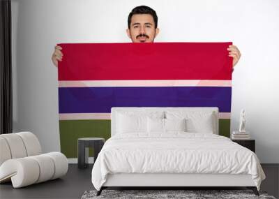 Young man holding Gambia flag, protest or social issues in Gambia, two hands and white background Wall mural