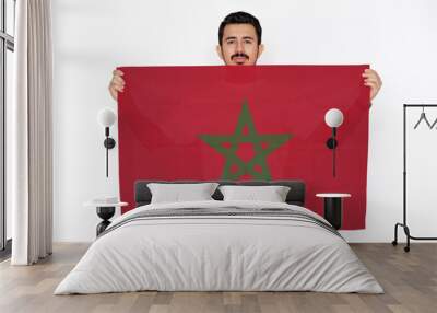 Young man holding Morocco flag, independence day idea, two hands and white background, celebration  Wall mural