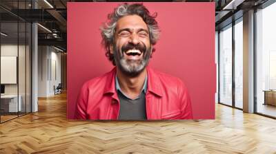 A man with a beard and gray hair is smiling and laughing Wall mural