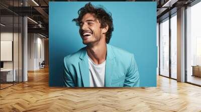 Handsome young man smiling while standing against blue background. created by generative AI technology. Wall mural