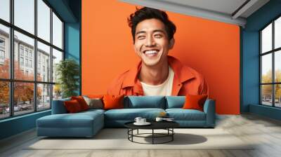 happy handsome fashion man smiling and wearing color cloth, solid light color background Wall mural