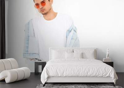 portrait of handsome young model man dressed in jeans clothes in sunglasses posing on white backgrou Wall mural