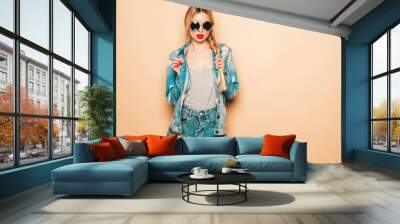 Portrait of young beautiful hipster bad girl in trendy jeans summer clothes and earring in her nose.Sexy carefree smiling blond woman posing in studio.Positive model having fun in sunglasses Wall mural